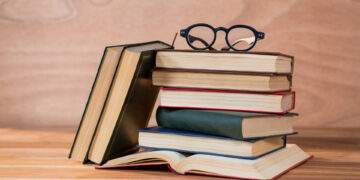 Various books with spectacles on a table